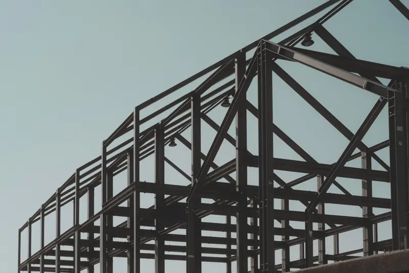 Bare steel frame of a new building under a clear sky